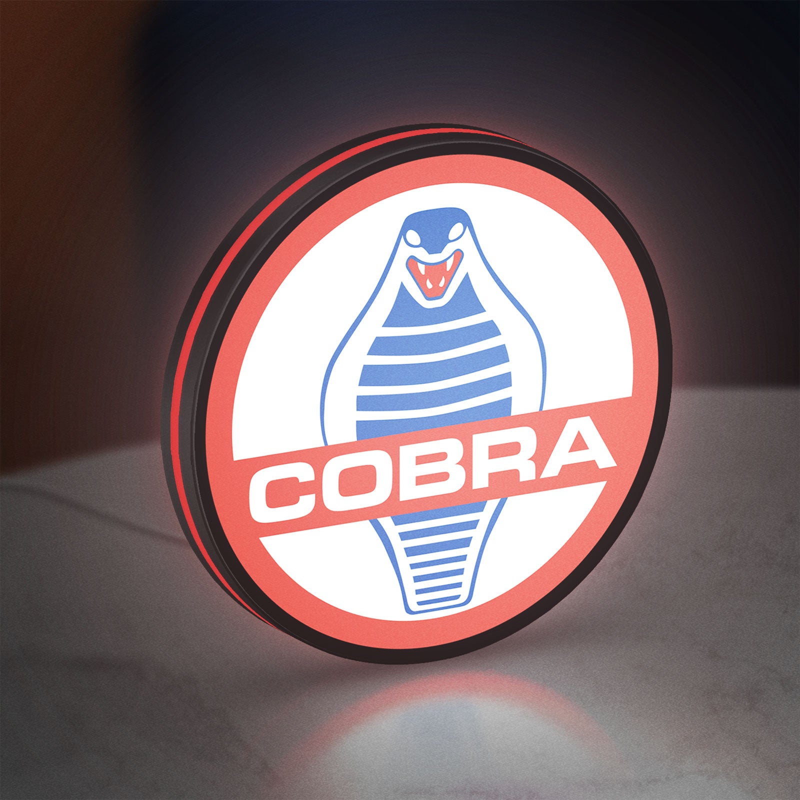 Cobra LED lightbox standing on a desk from an angled side view with red glow