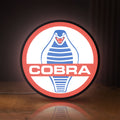 Front view of Cobra LED lightbox sign glowing on a wooden desk