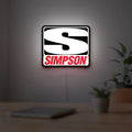 Simpson Racing LED lightbox hanging on a room wall with soft white light