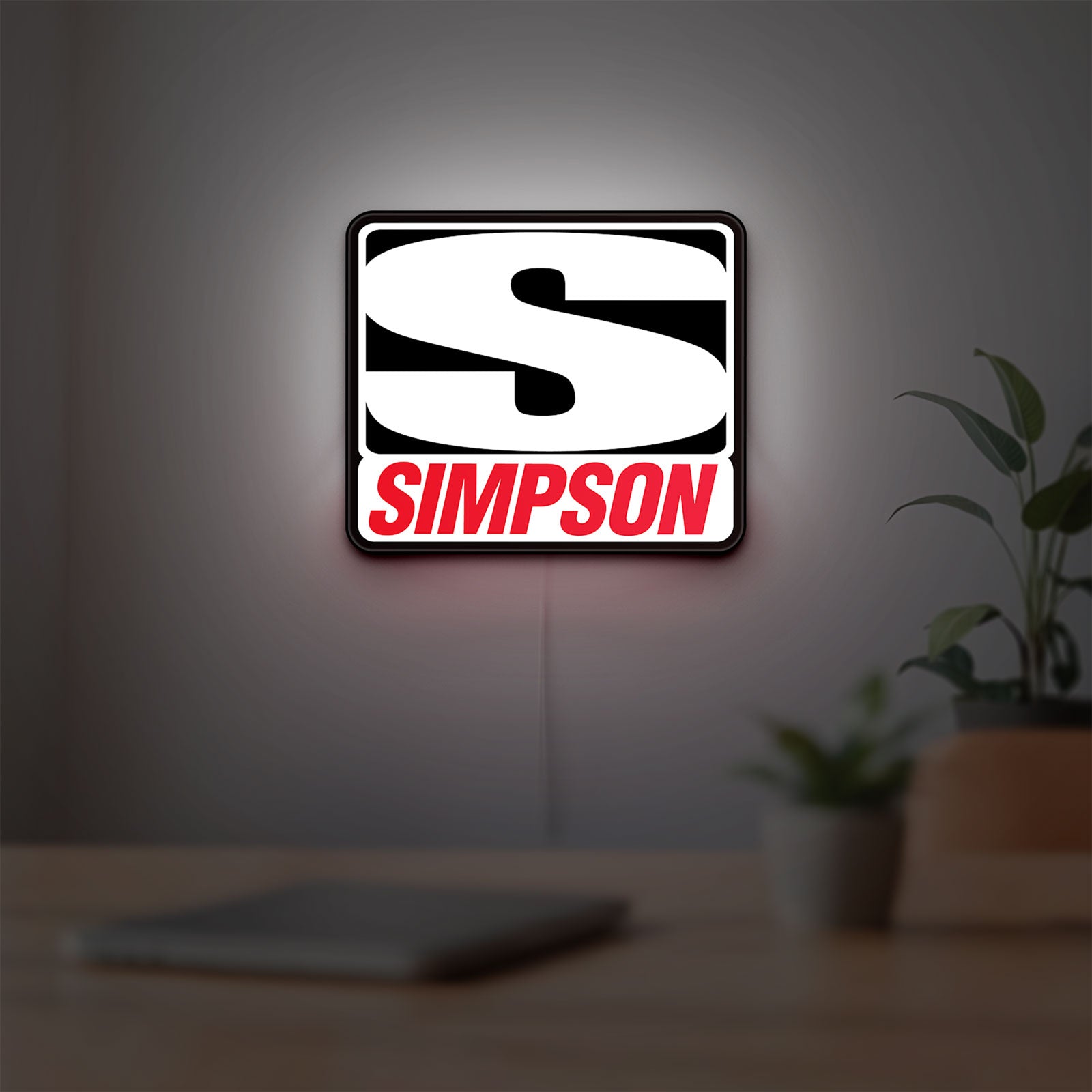 Simpson Racing LED lightbox hanging on a room wall with soft white light