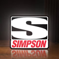 Front view of Simpson Racing LED lightbox sign glowing on a wooden desk