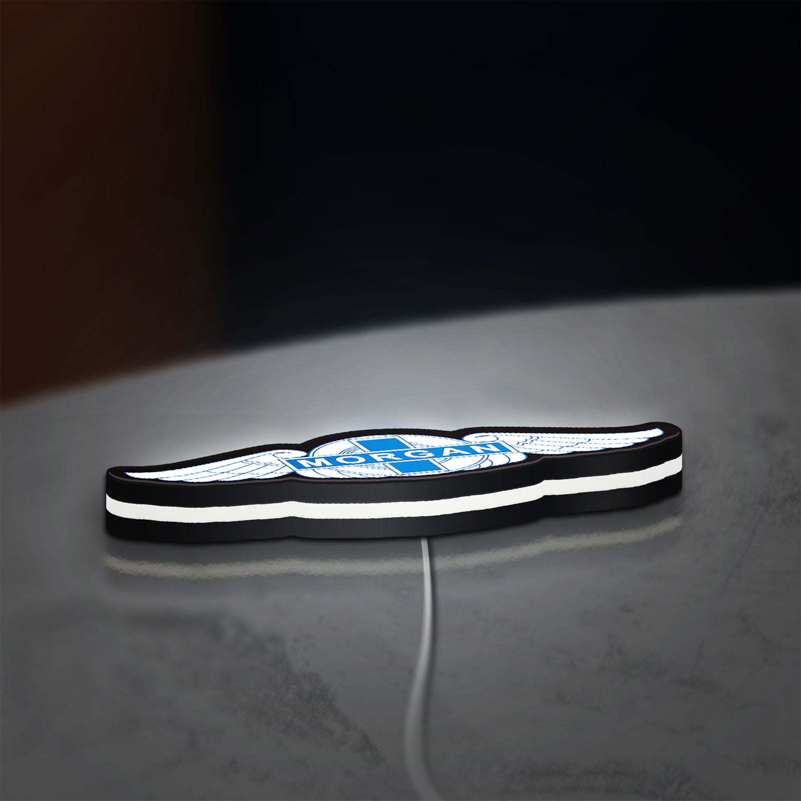 Morgan Motors LED lightbox lying flat on a desk with white glow