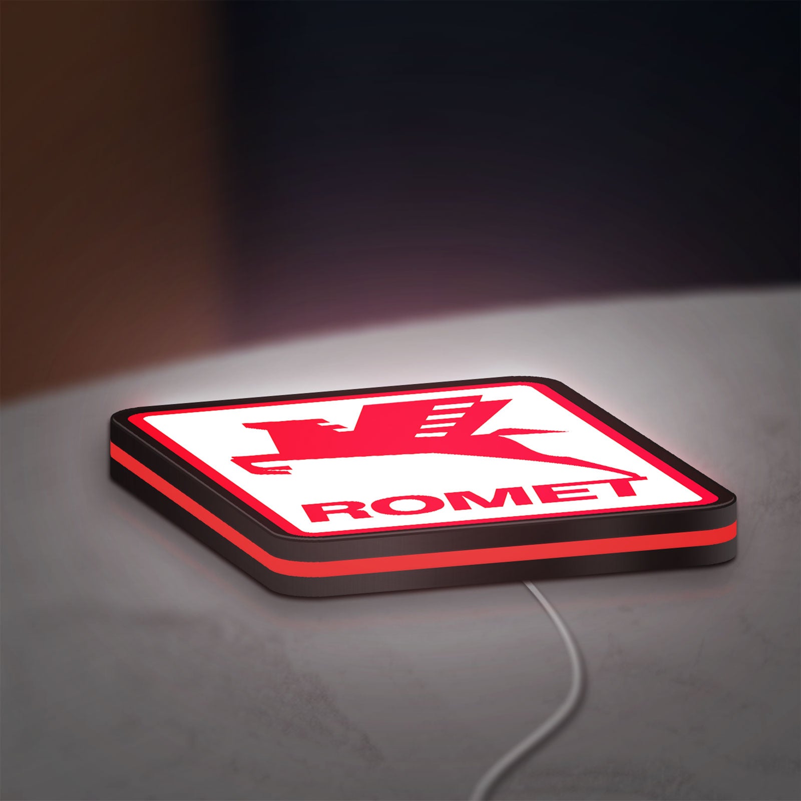Romet Sign LED lightbox lying flat on a desk with red glow