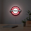 Drudi Performance LED lightbox hanging on a room wall with soft red light