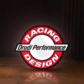 Front view of Drudi Performance LED lightbox sign glowing on a wooden desk