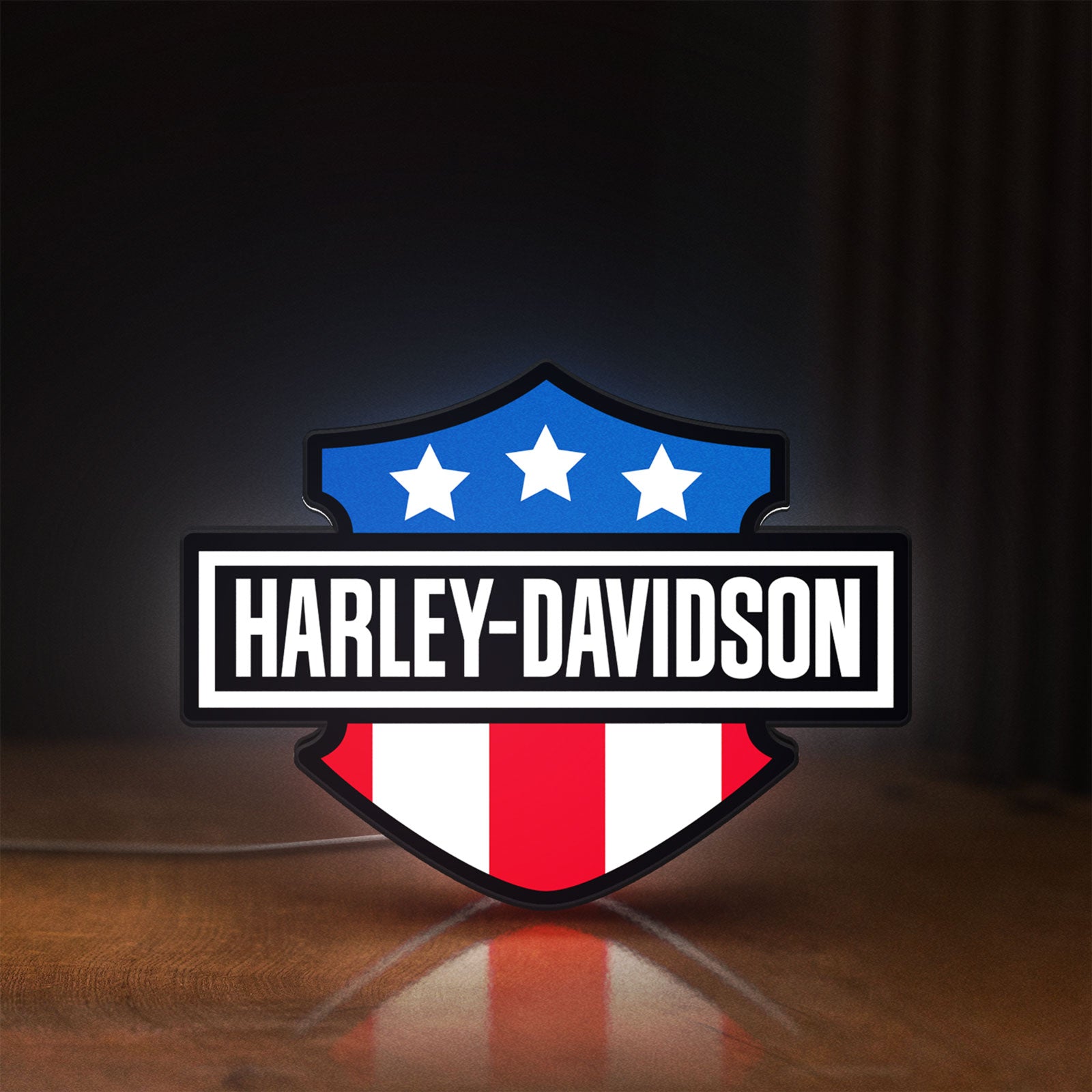 Front view of Harley Shield Motorcycle LED lightbox sign glowing on a wooden desk