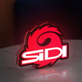 Sidi Cycling LED lightbox standing on a desk from an angled side view with red glow