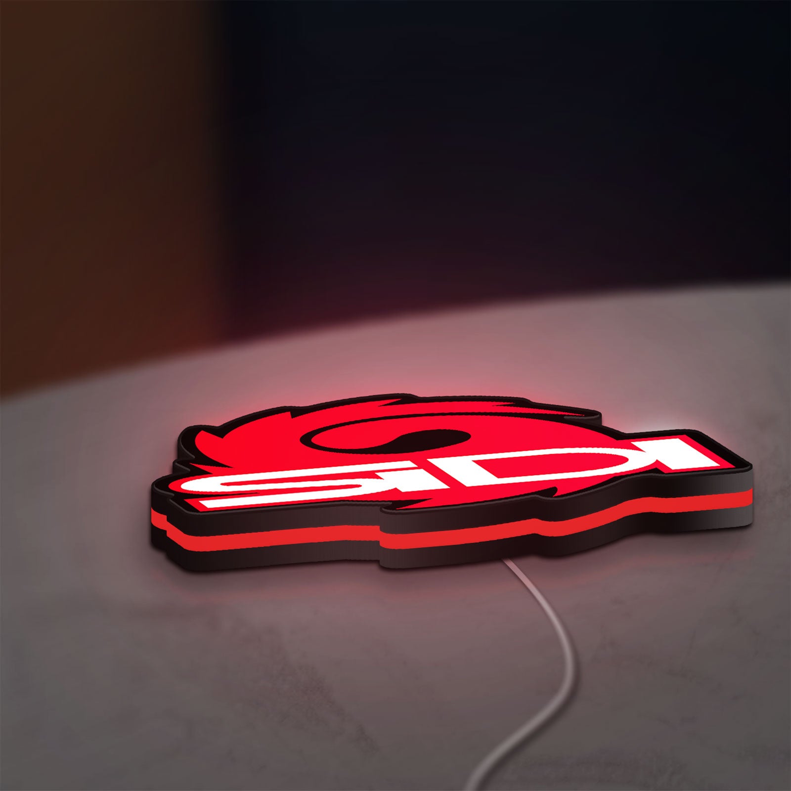 Sidi Cycling LED lightbox lying flat on a desk with red glow