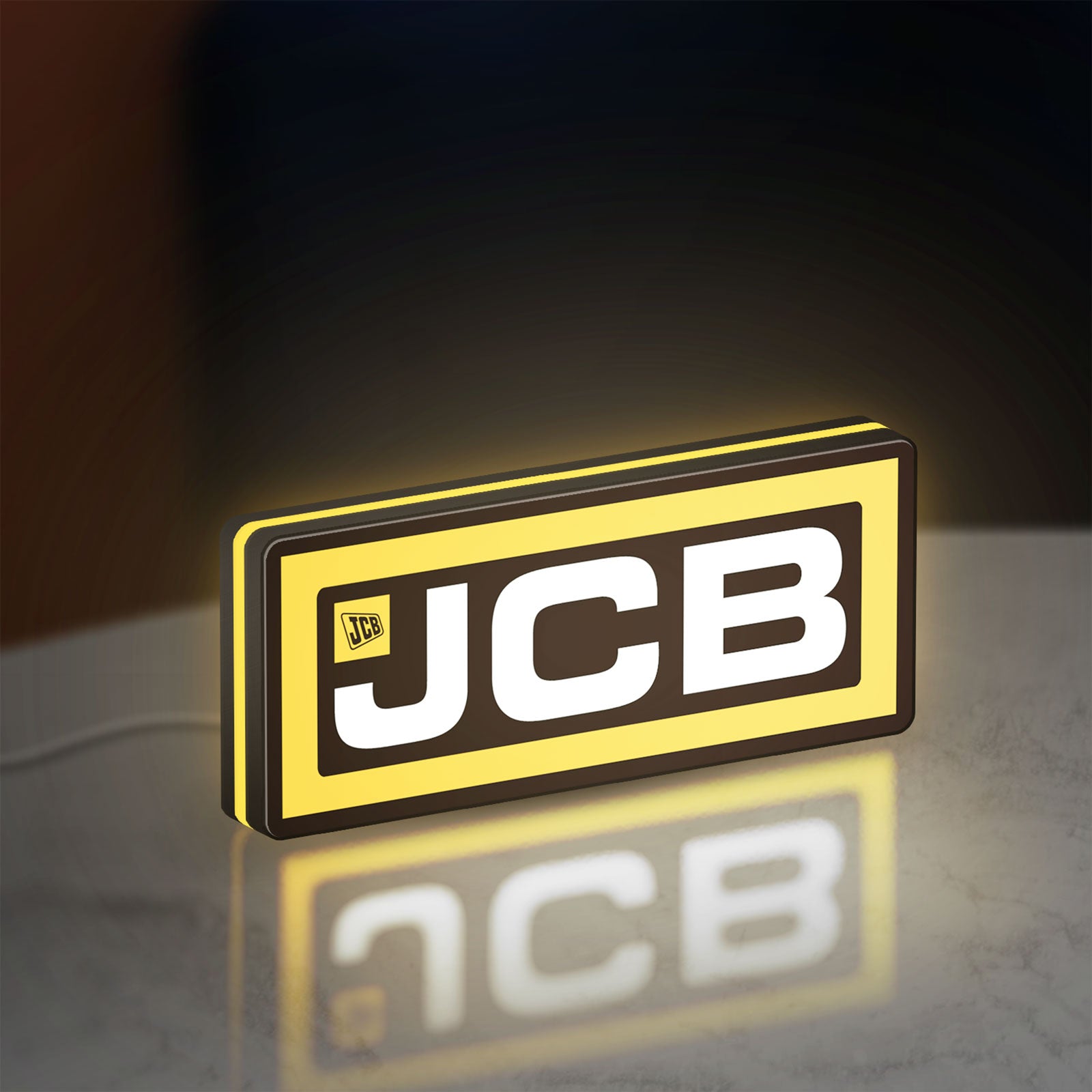 JCB Heavy Equipment LED lightbox standing on a desk from an angled side view with yellow glow