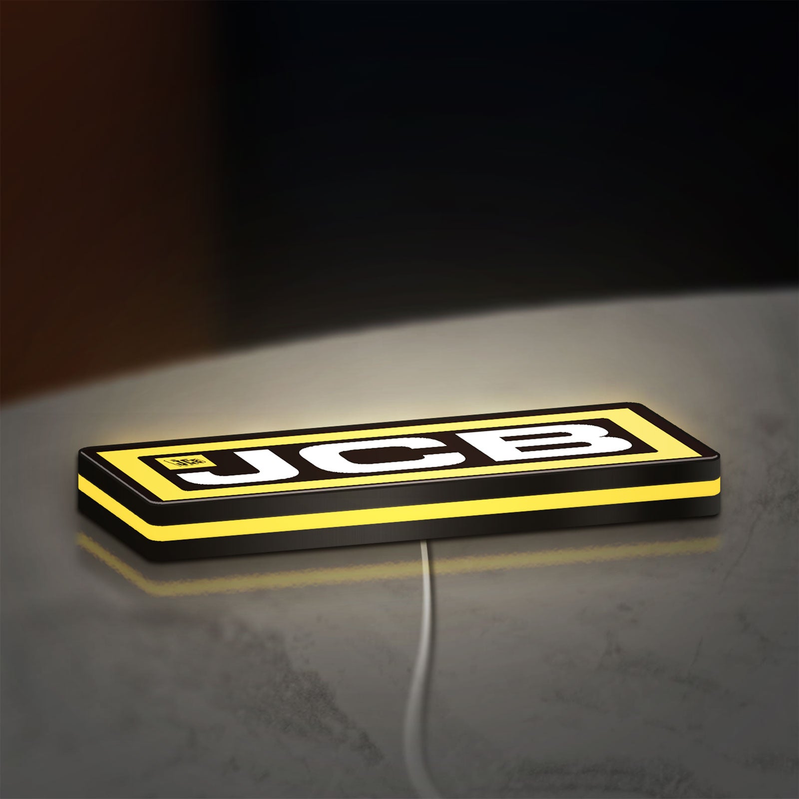 JCB Heavy Equipment LED lightbox lying flat on a desk with yellow glow