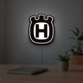 Husqvarna LED lightbox hanging on a room wall with soft white light