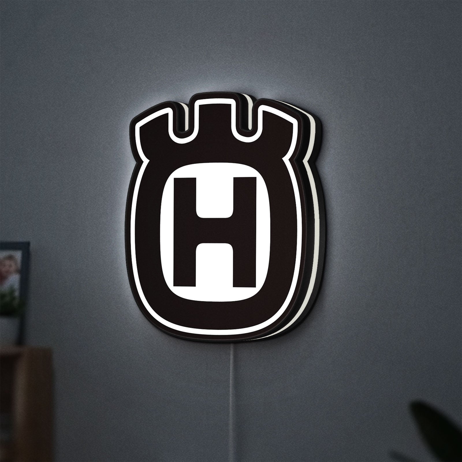 Husqvarna LED lightbox hanging on a wall with white glow