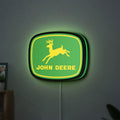 John Deere LED lightbox hanging on a wall with green glow