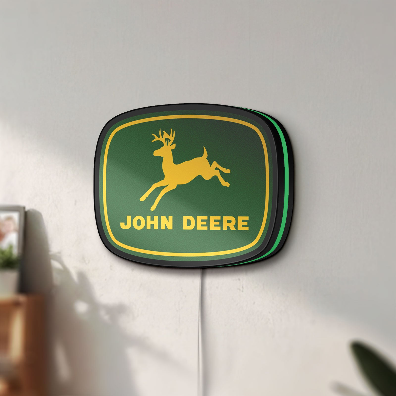 Unlit John Deere LED lightbox mounted on a wall in daylight
