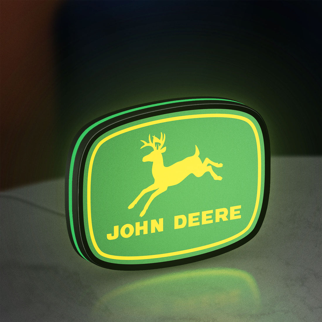 John Deere LED lightbox hanging on a wall with green glow