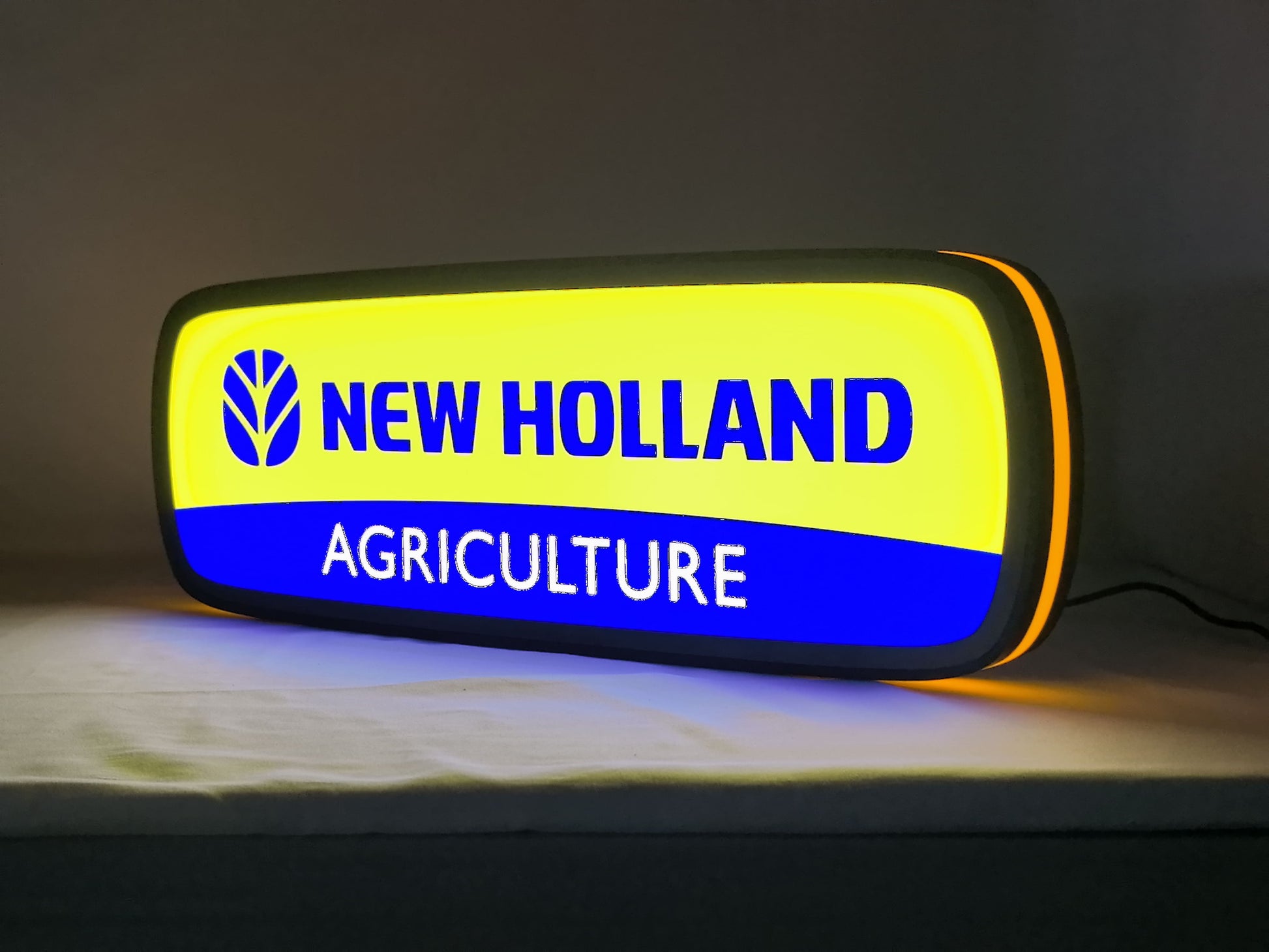 New Holland Agriculture LED Sign (50cm) - Illuminated angled view standing, perfect for garage and man cave decor