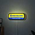 New Holland Agriculture LED lightbox hanging on a wall with yellow glow