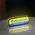 New Holland Agriculture LED lightbox standing on a desk from an angled side view with yellow glow