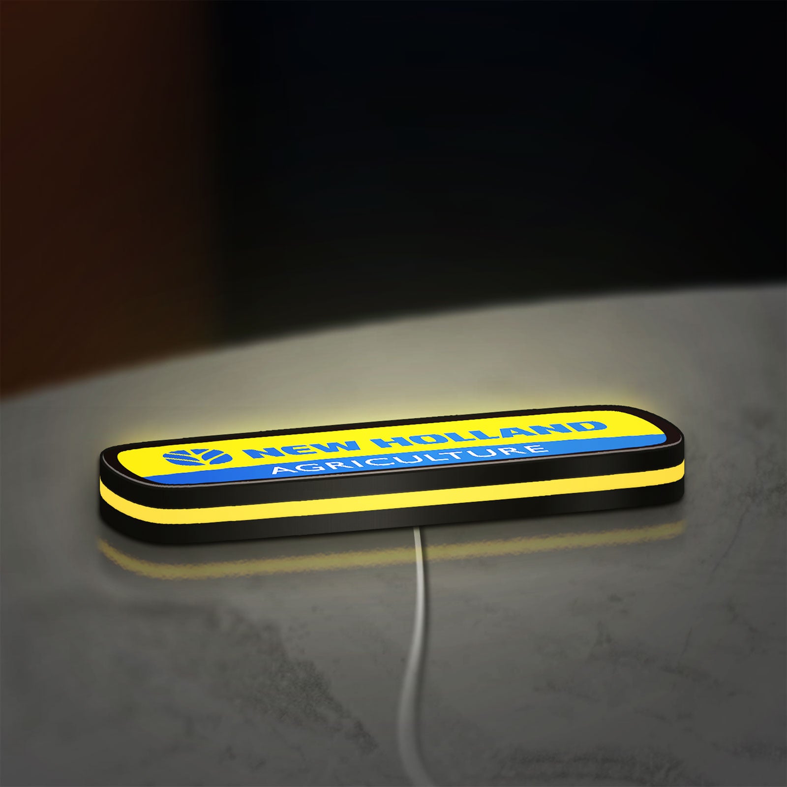 New Holland Agriculture LED lightbox lying flat on a desk with yellow glow