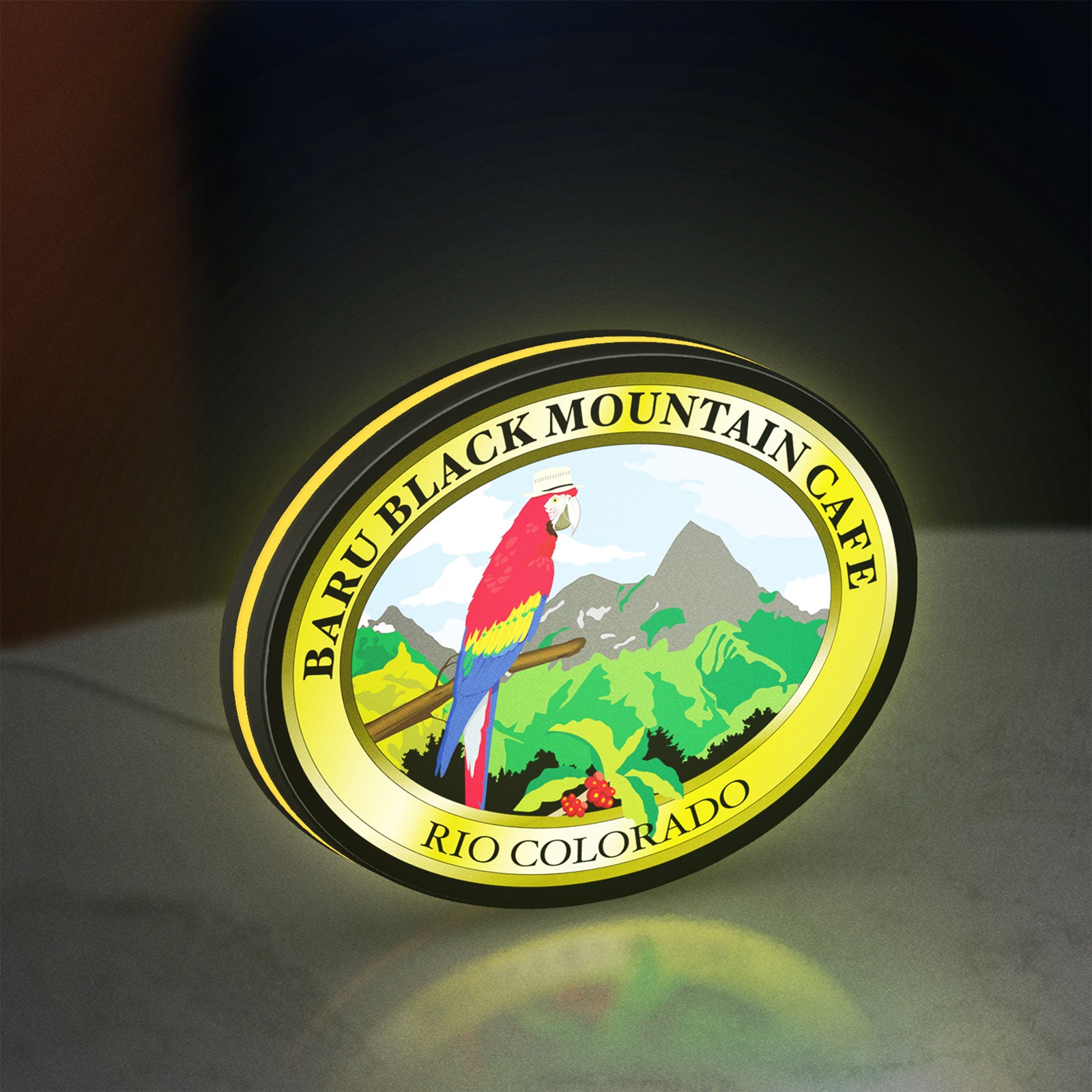 Baru Black Mountain Cafe LED lightbox standing on a desk from an angled side view with yellow glow
