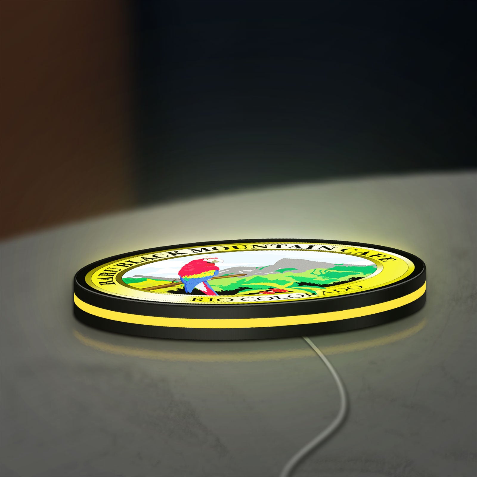 Baru Black Mountain Cafe LED lightbox lying flat on a desk with yellow glow