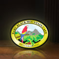 Front view of Baru Black Mountain Cafe LED lightbox sign glowing on a wooden desk