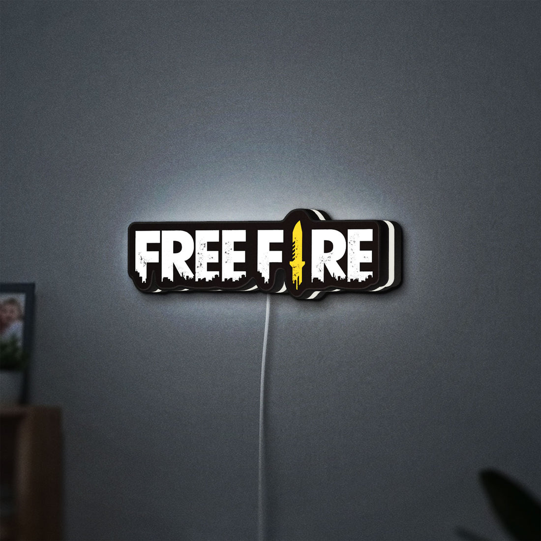 Free Fire LED lightbox hanging on a wall with white glow
