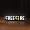 Front view of Free Fire LED lightbox sign glowing on a wooden desk