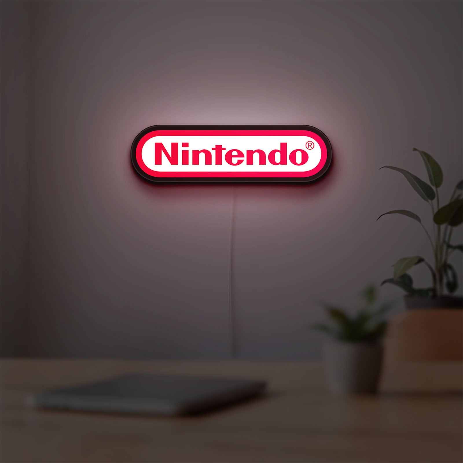 Nintendo LED lightbox hanging on a room wall with soft red light