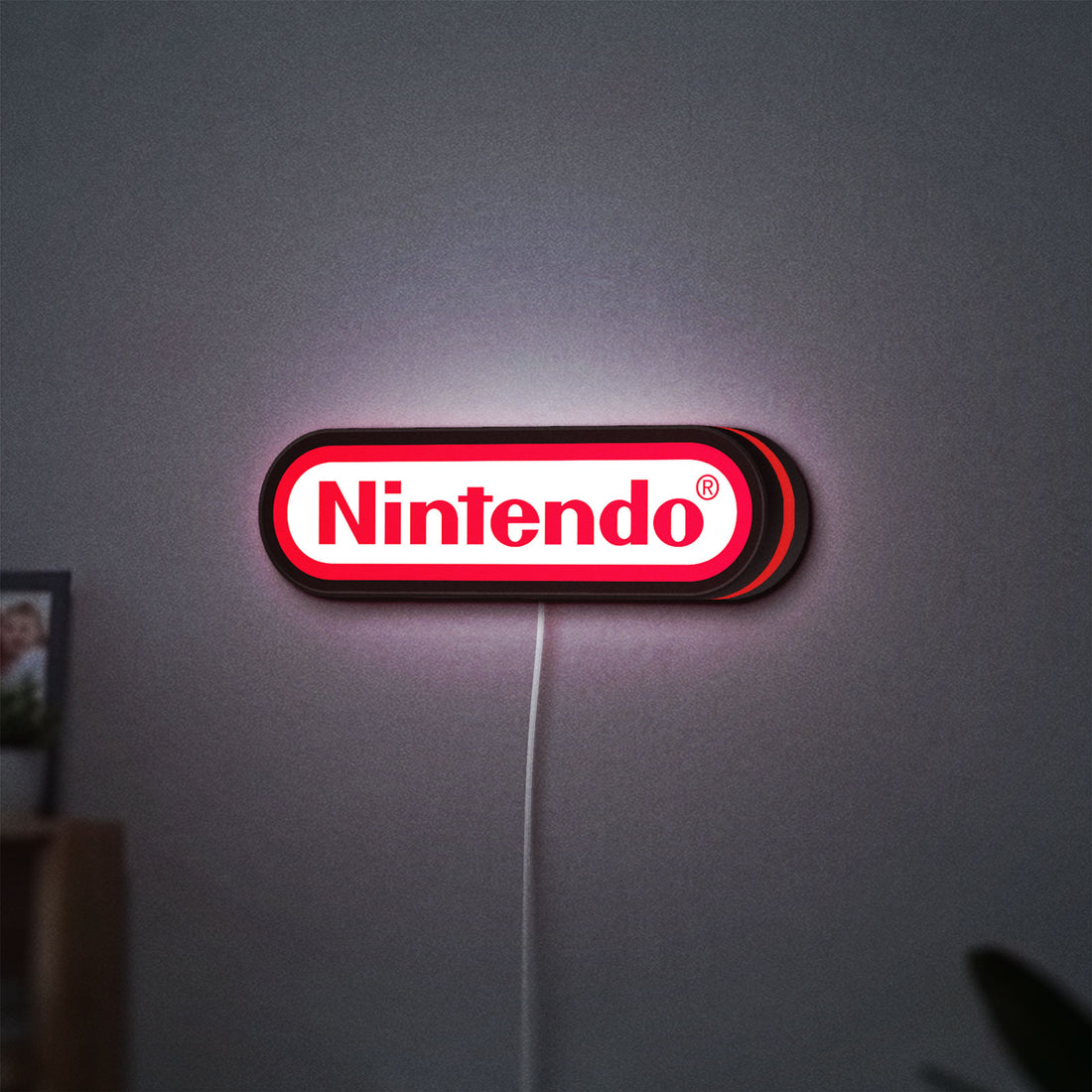 Nintendo LED lightbox hanging on a wall with red glow