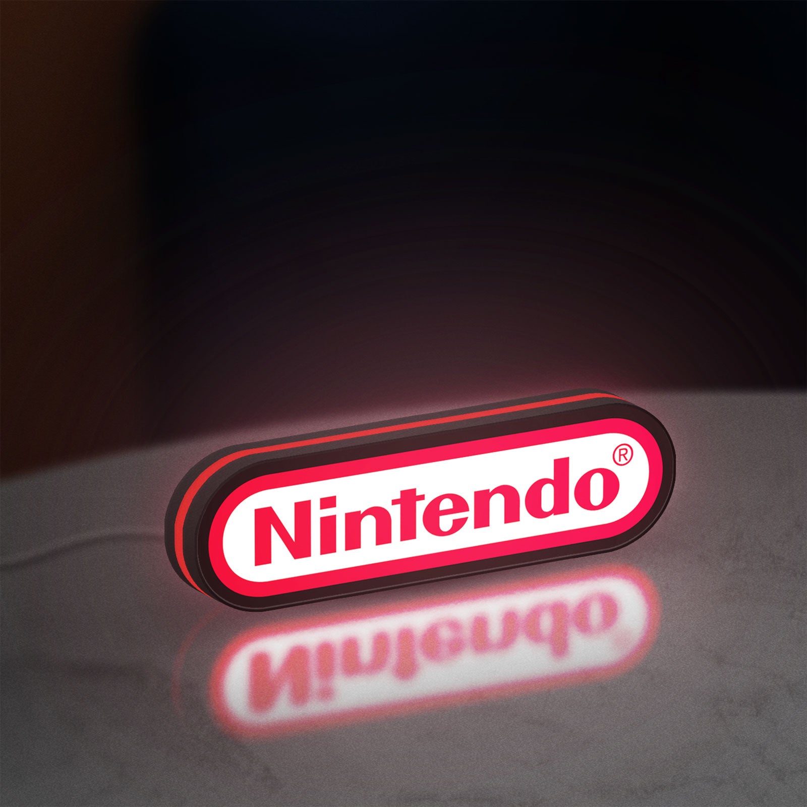 Nintendo LED lightbox standing on a desk from an angled side view with red glow
