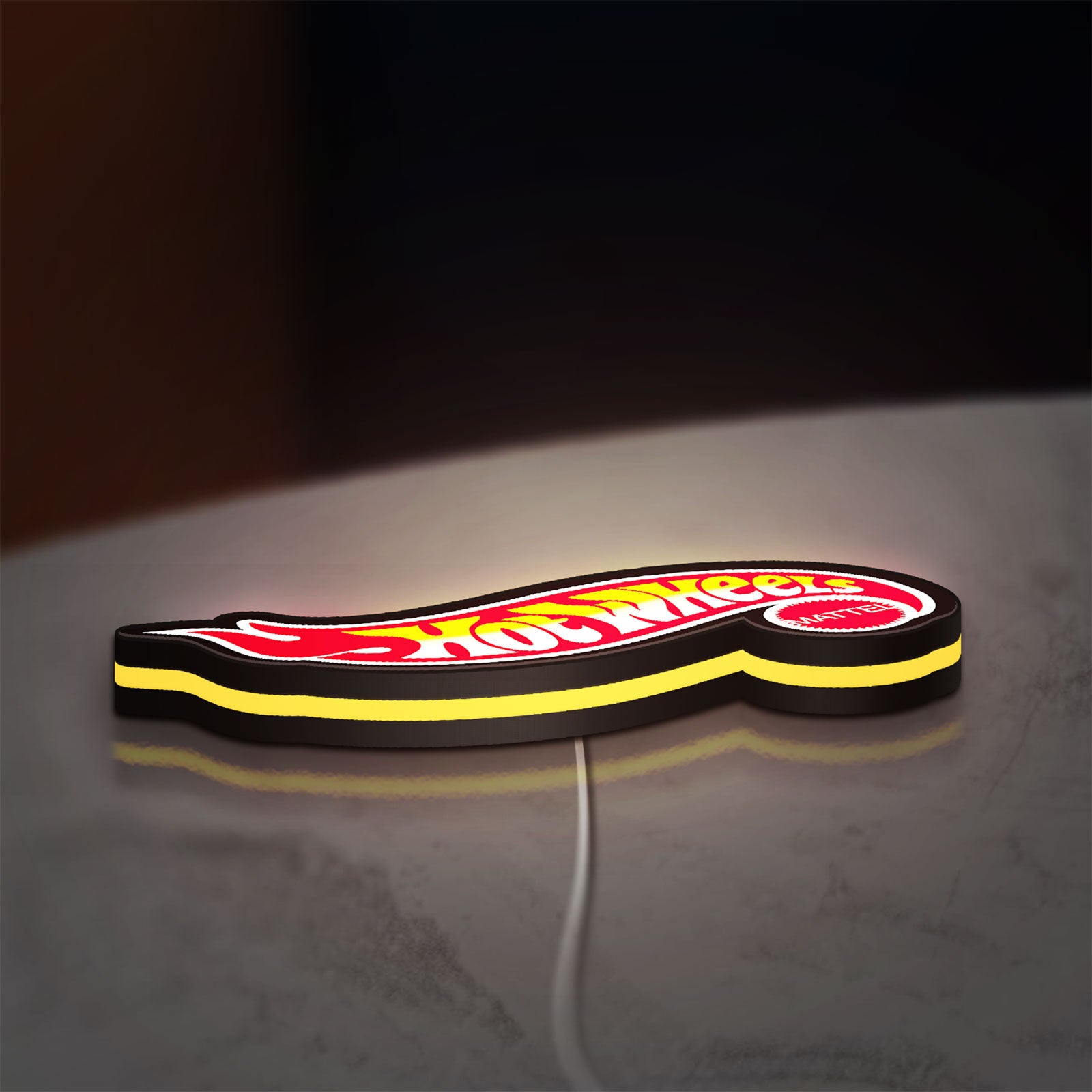 Hot Wheels Flame Racing Car LED lightbox lying flat on a desk with yellow glow