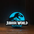Front view of Jurassic World Dinosaur LED lightbox sign glowing on a wooden desk