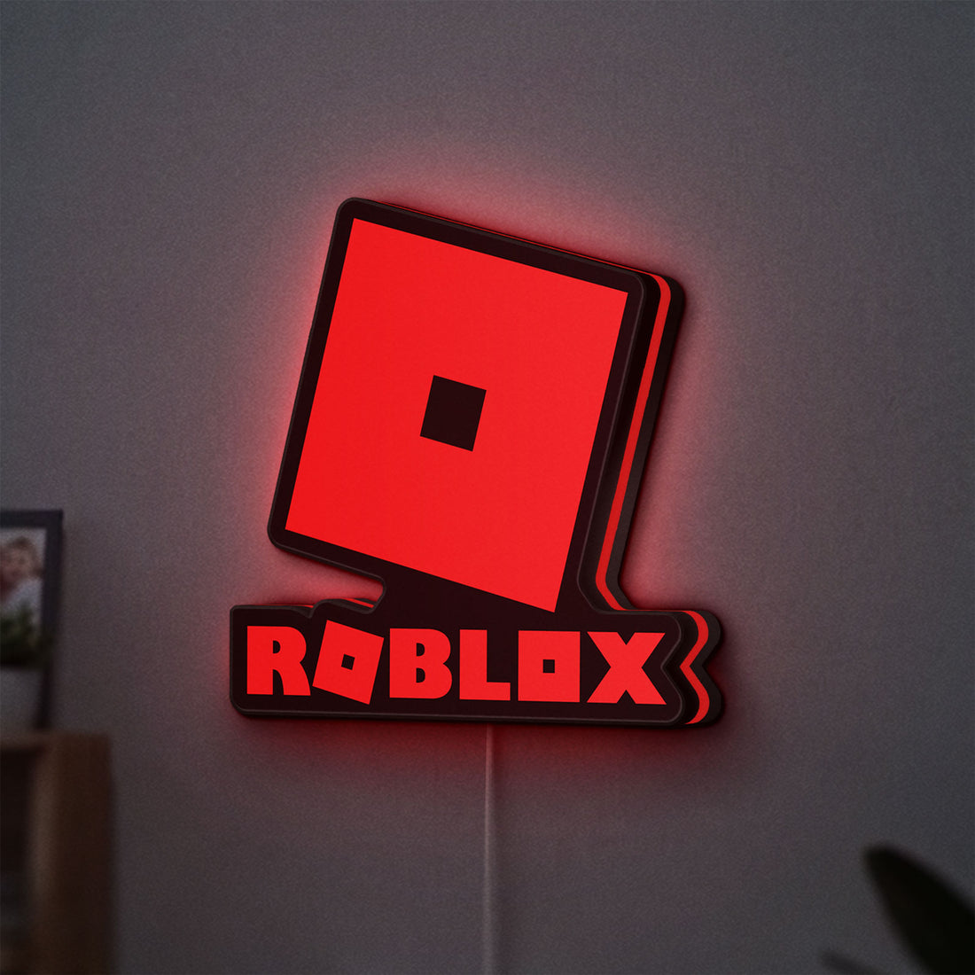 Roblox LED lightbox hanging on a wall with red glow