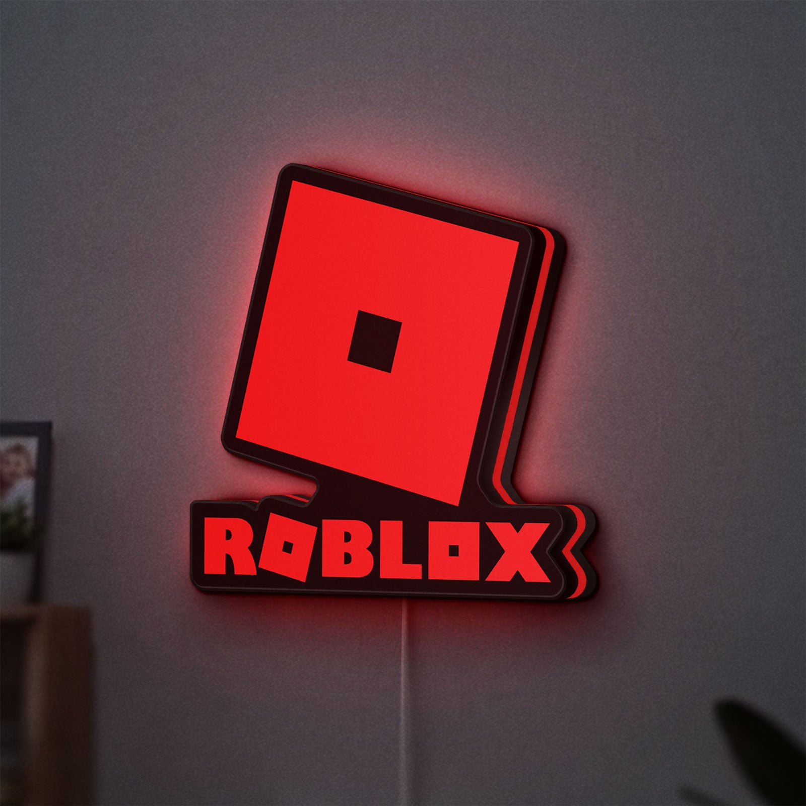 Roblox LED lightbox hanging on a wall with red glow