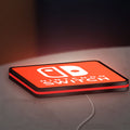 Nintendo Switch LED lightbox lying flat on a desk with red glow
