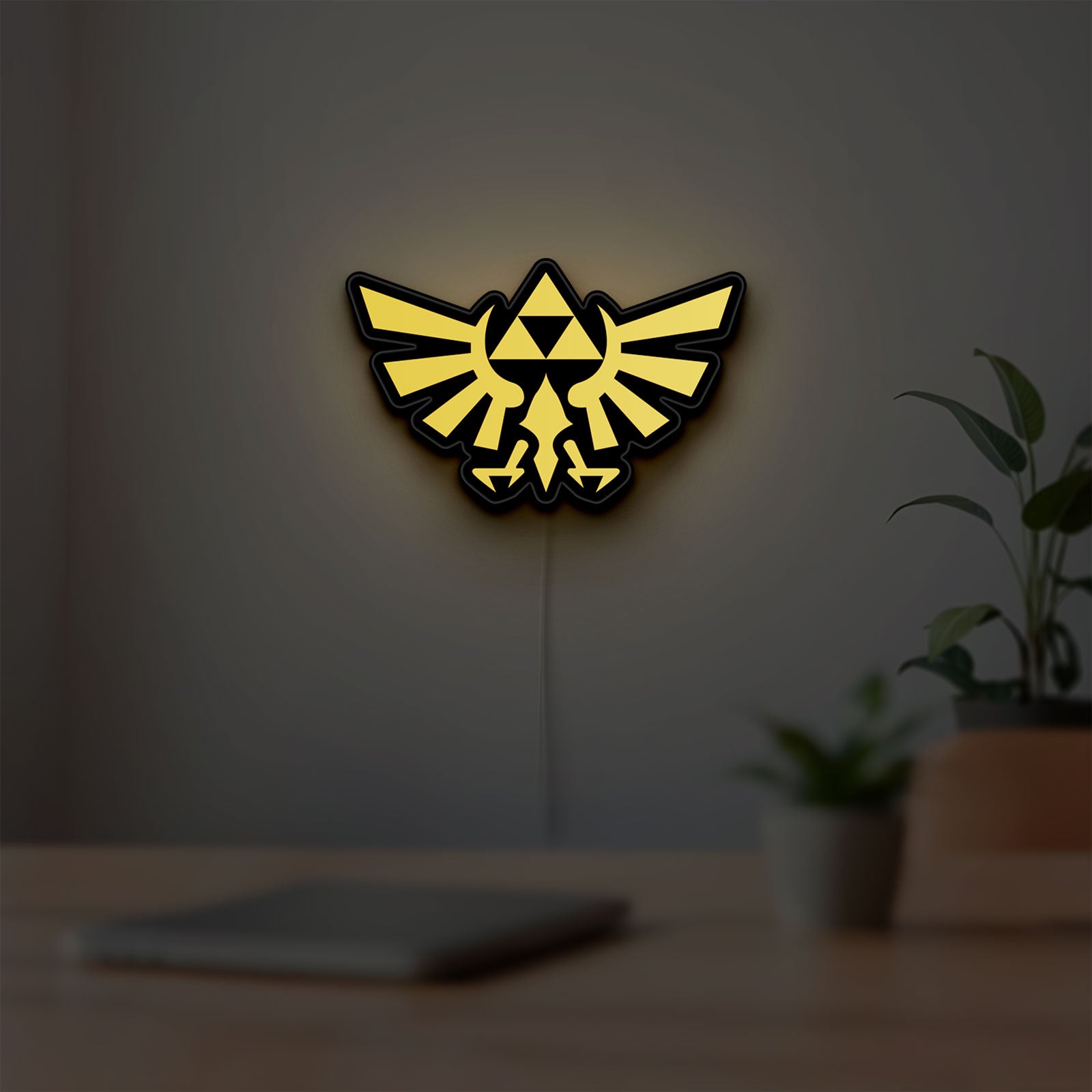 The Legend of Zelda Hyrulian Crest LED lightbox hanging on a room wall with soft yellow light