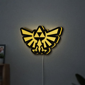 The Legend of Zelda Hyrulian Crest LED lightbox hanging on a wall with yellow glow