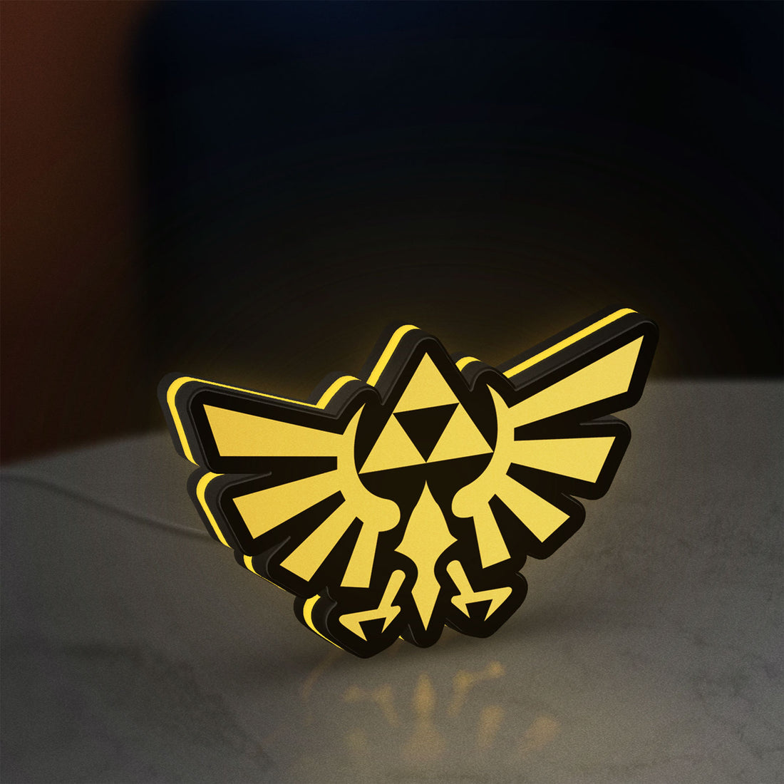 The Legend of Zelda Hyrulian Crest LED lightbox hanging on a wall with yellow glow