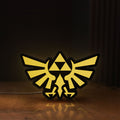 Front view of The Legend of Zelda Hyrulian Crest LED lightbox sign glowing on a wooden desk