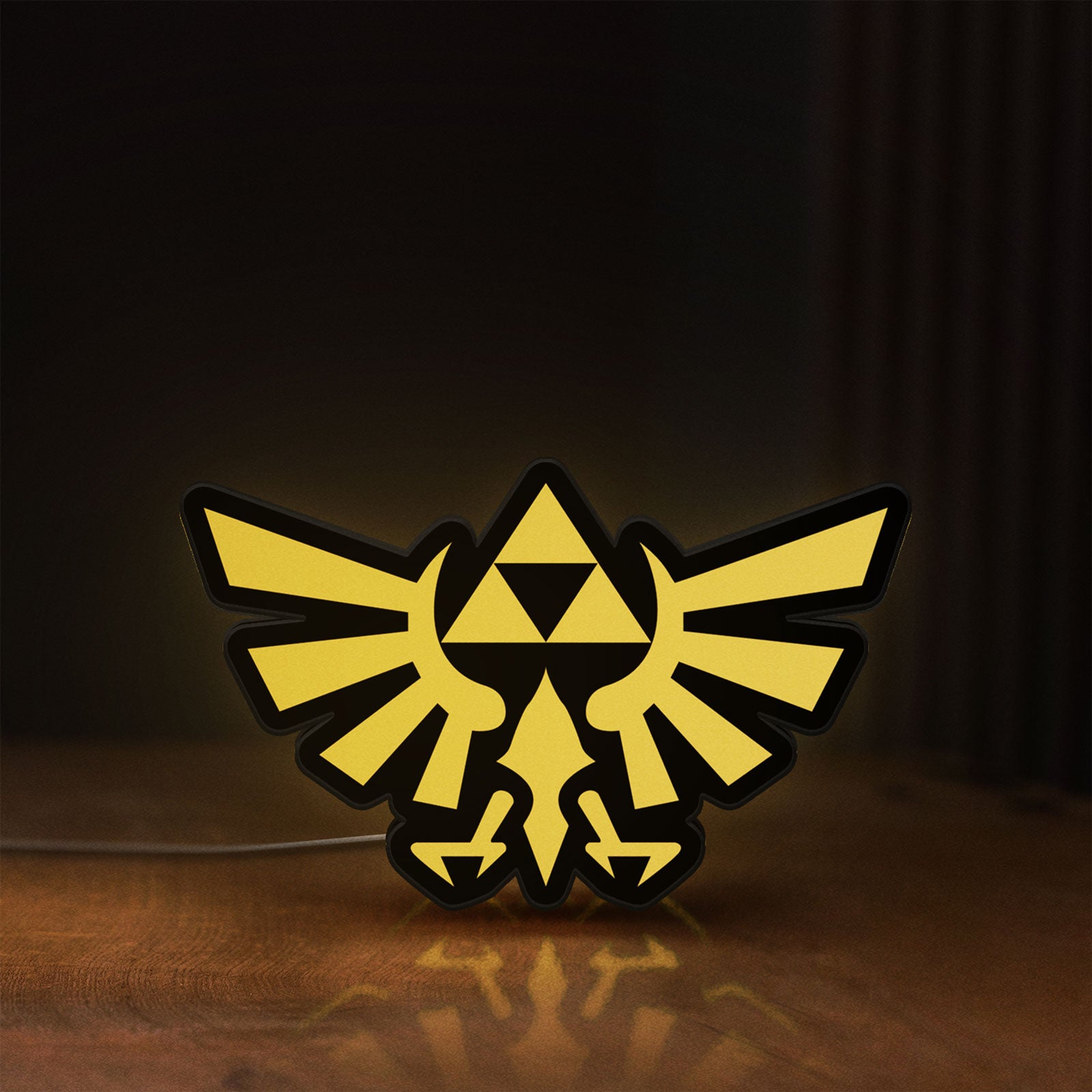 Front view of The Legend of Zelda Hyrulian Crest LED lightbox sign glowing on a wooden desk
