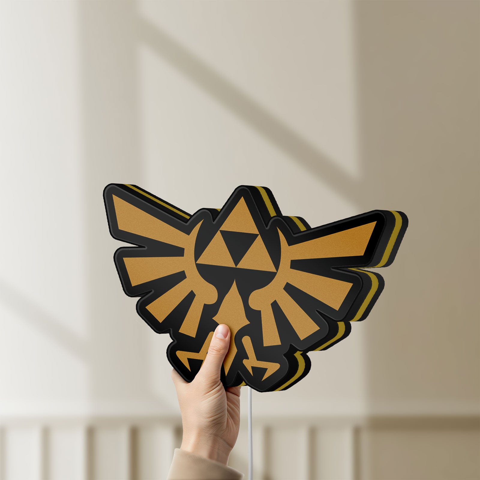 Unlit The Legend of Zelda Hyrulian Crest LED lightbox held by hand to show size and details