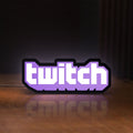 Front view of Twitch LED lightbox sign glowing on a wooden desk