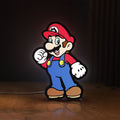 Front view of Super Mario LED lightbox sign glowing on a wooden desk