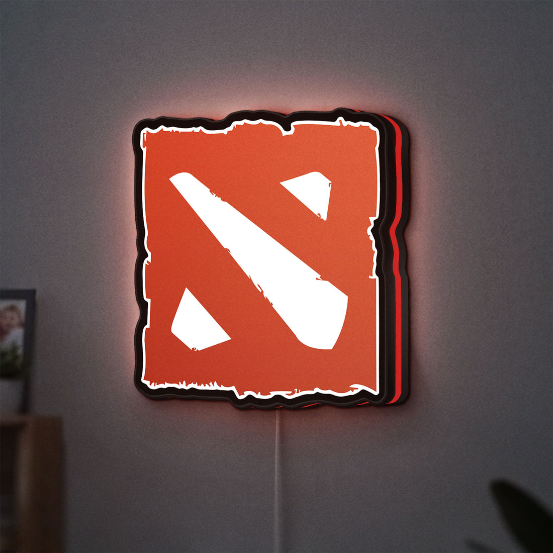 Dota LED lightbox hanging on a wall with red glow