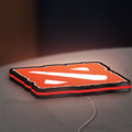 Dota LED lightbox lying flat on a desk with red glow
