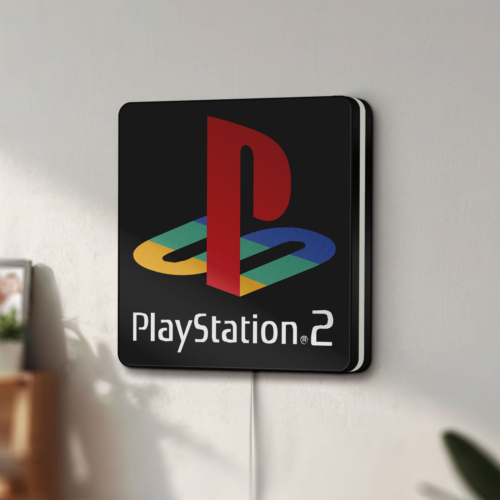 Unlit PLAYSTATION 2 LED lightbox mounted on a wall in daylight