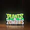 Front view of Plants vs Zombies LED lightbox sign glowing on a wooden desk