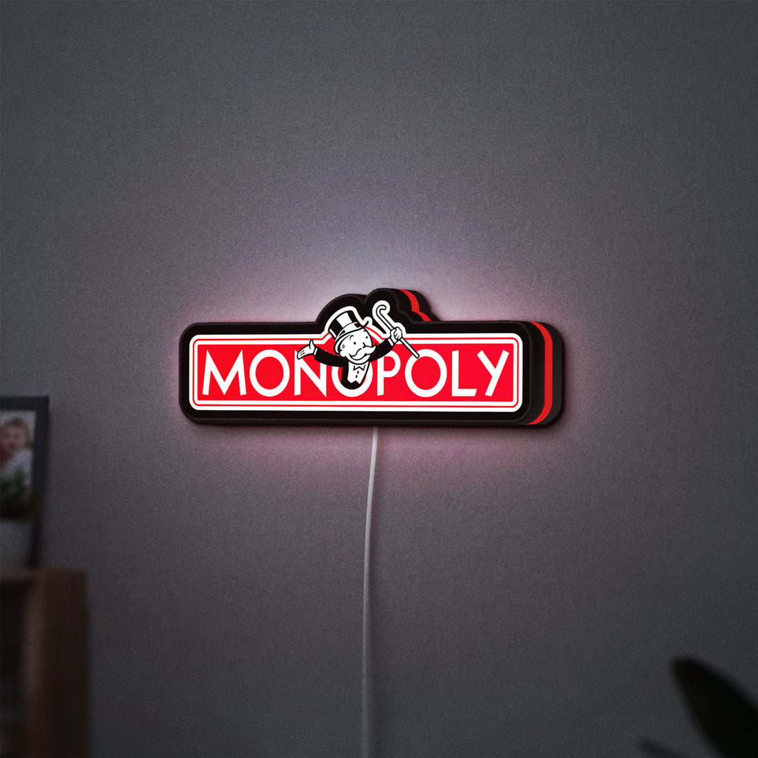 Monopoly Money Bag LED lightbox hanging on a wall with red glow