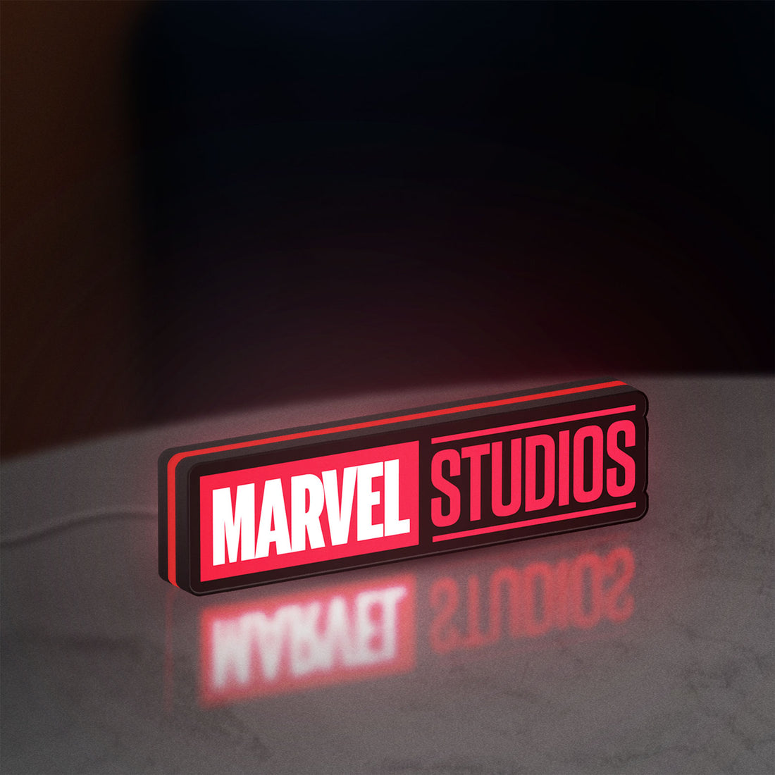 Marvel Studios LED lightbox hanging on a wall with red glow